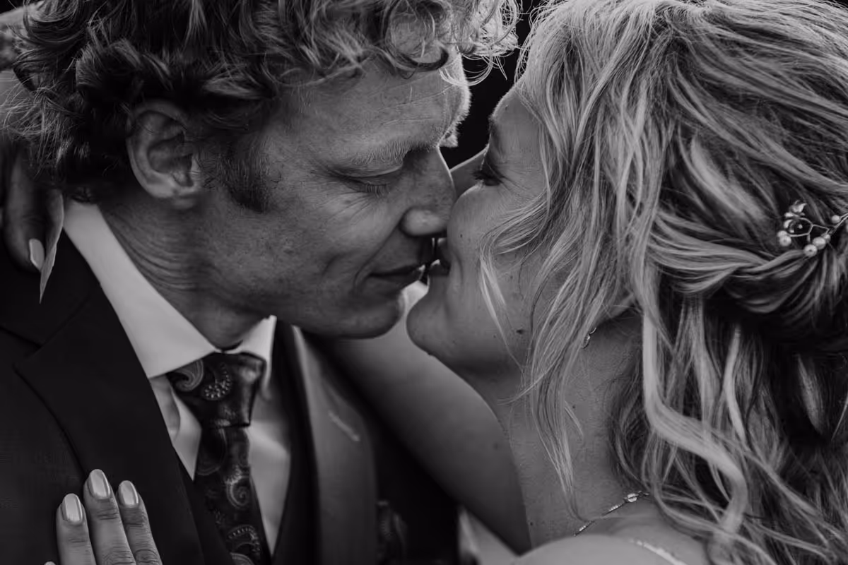 close up foto van bruidspaar met gezichten dicht bij elkaar in zwart wit