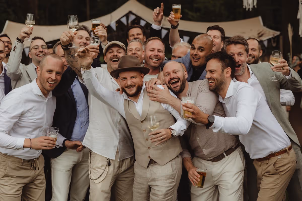 Bruidegom met vrienden die proosten met bier