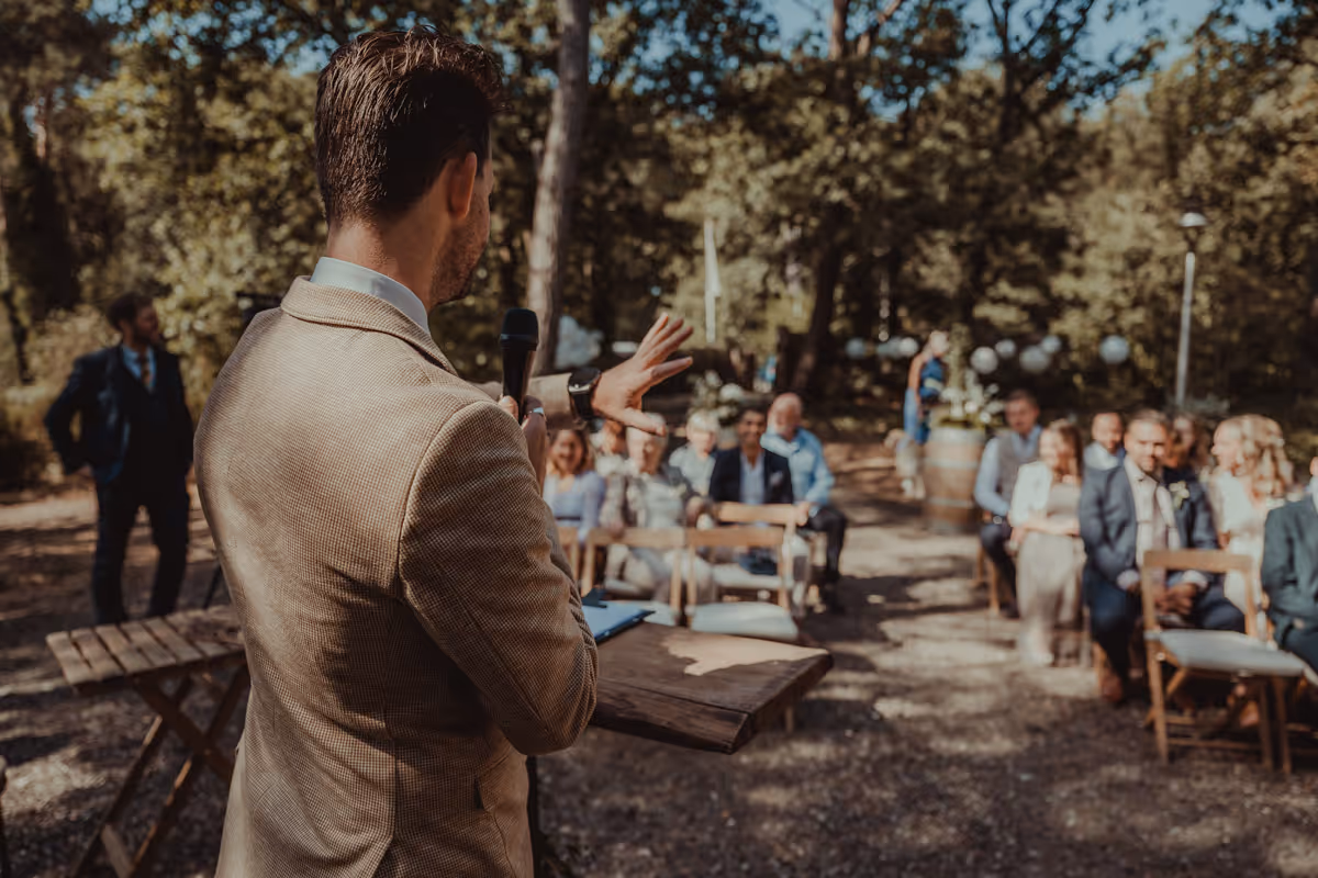 trouwceremonie in bos met gasten in beeld