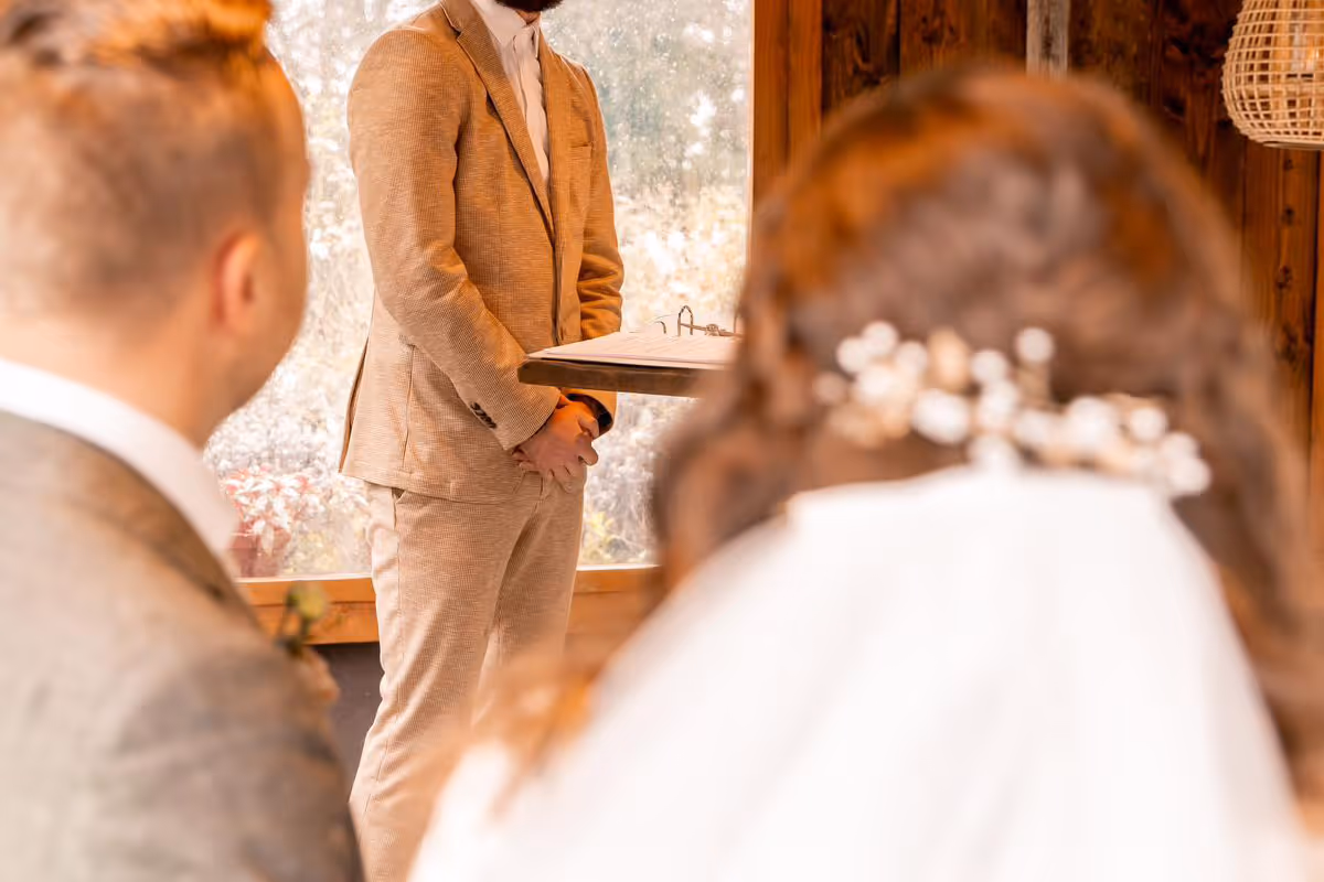 bruidspaar close up met babs op de achtergrond