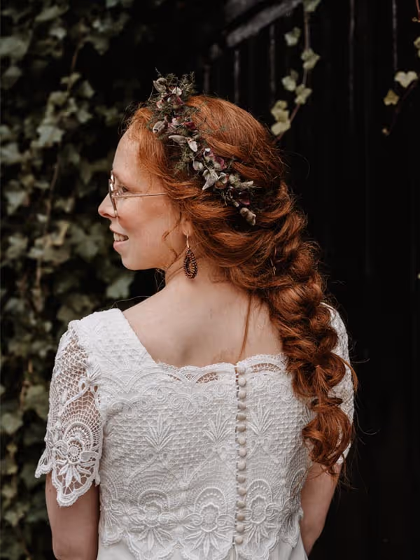 rrood harige bruid van de achterkant en zij profiel met een mooi gevlochten kapsel en een bloemenkroon