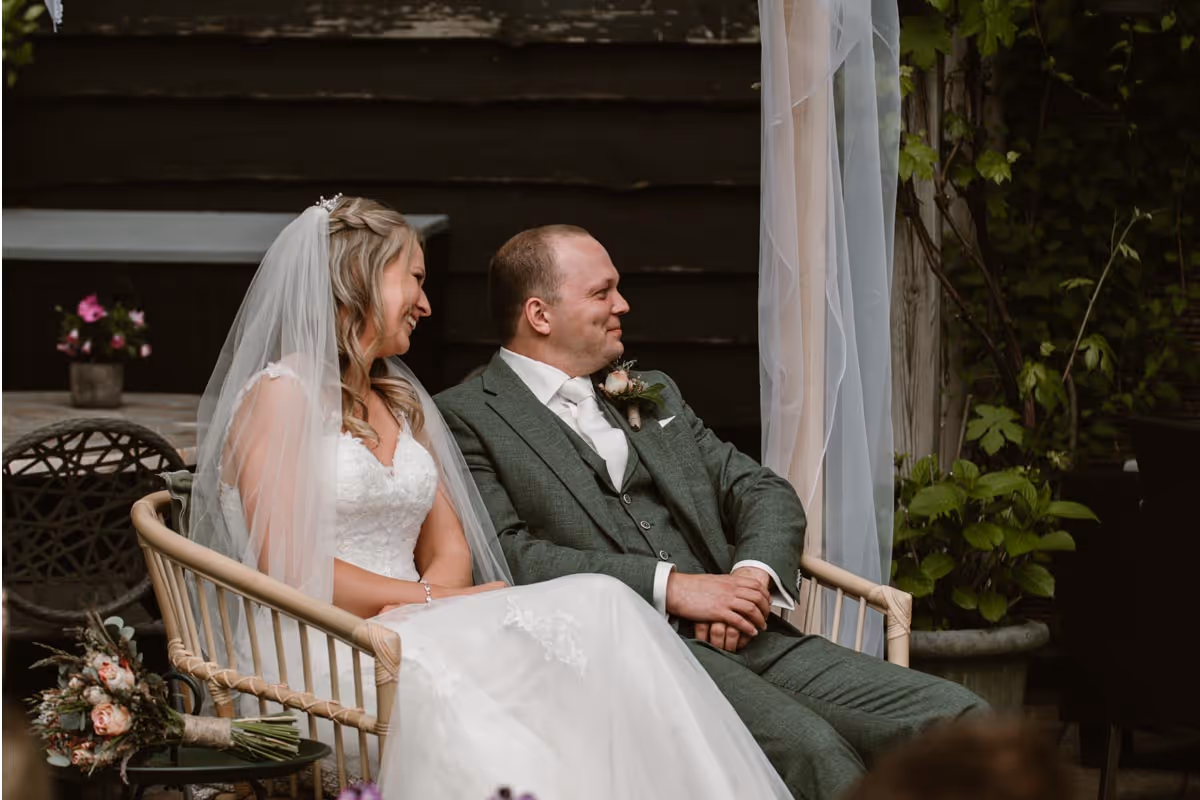 Close up bruidspaar op het trouwbankje tijdens ceremonie
