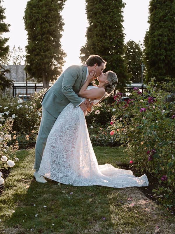 kussend bruidspaar met mooi lichtval door de kanten trouwjurk