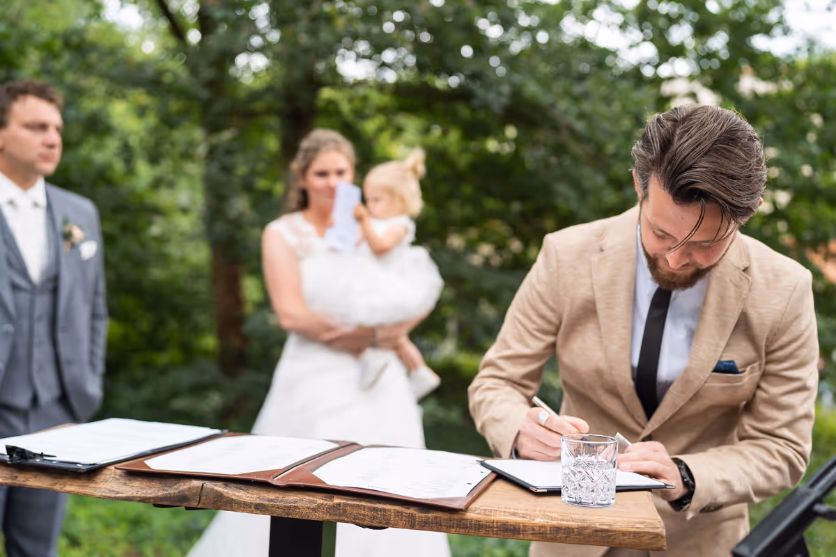Babs Hofman aan het tekenen met bruidspaar op de achtrgrond