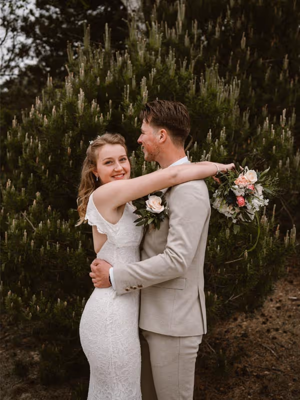 Bruidspaar tijdens fotoshoot omarmd