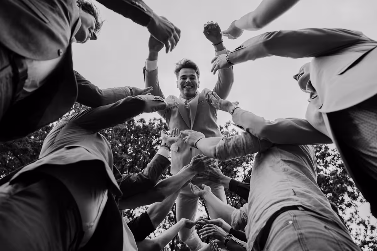 vliegen bruidegom, je ziet de bruidegom zweven din de luchten en de armen van de vrienden die hem in de lucht gegooid hebbe